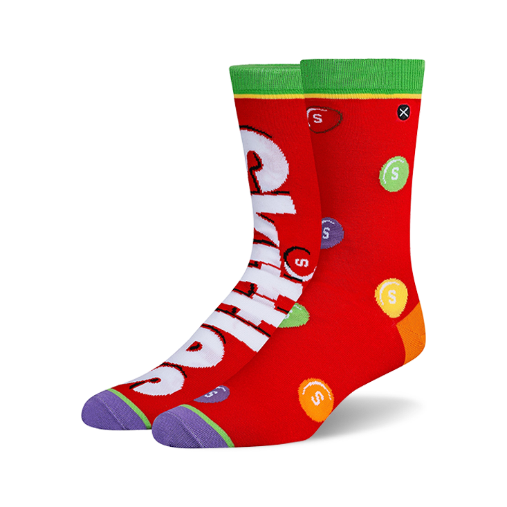 Pair of crew socks, predominantly red, featuring a Skittles design with the Skittles logo and multicolored candies printed on them.