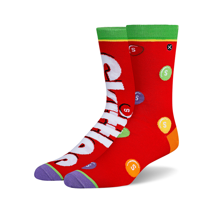 Pair of crew socks, predominantly red, featuring a Skittles design with the Skittles logo and multicolored candies printed on them.