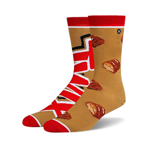 Pair of crew socks in tan and red. One sock features the Twix logo, the other has scattered Twix bar images.