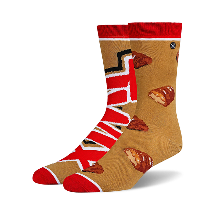 Pair of crew socks in tan and red. One sock features the Twix logo, the other has scattered Twix bar images.