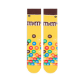 Flat lay of yellow crew socks showing a brown cuff, the M&M's logo on the calf, and colorful M&M candies piled at the toe.