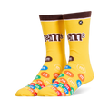 Bright yellow crew socks featuring a brown cuff, the M&M's logo on the leg, and a colorful pile of M&M candies on the foot.