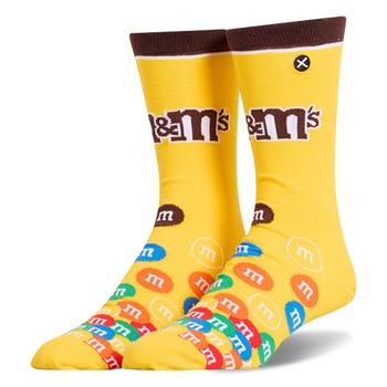 Bright yellow crew socks featuring a brown cuff, the M&M's logo on the leg, and a colorful pile of M&M candies on the foot.