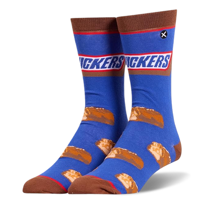 Blue crew socks featuring the Snickers logo at the calf, brown accents, and a pattern of sliced mini chocolate candy bars.