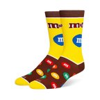 Yellow and brown M&M's crew socks with the classic logo on the leg and a pattern of colorful candy pieces on the dark foot.