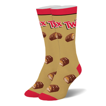 Gold crew socks with a red top, toe, and heel, featuring the Twix logo and a pattern of broken chocolate caramel bars.