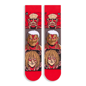 Flat lay of Attack on Titan socks showing the full front design with stacked Titan faces and bright red toes and cuffs.