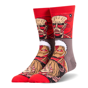 Red and grey crew socks displaying stacked Attack on Titan faces, featuring the Colossal, Armored, and Female Titans.