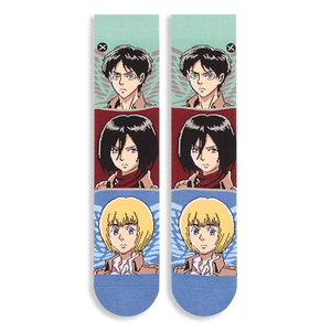 Flat lay of two crew socks side by side showing horizontal color blocks featuring determined anime character faces.