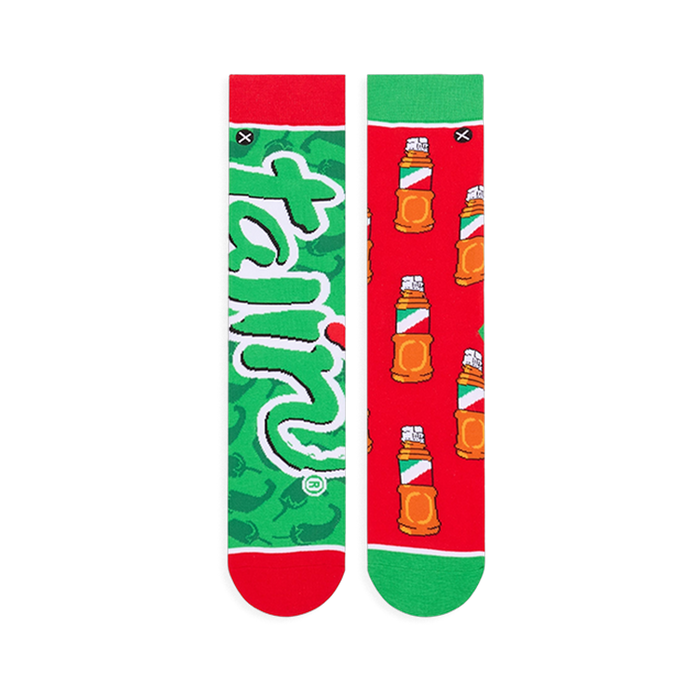 Flat lay of the mismatched socks. The green sock shows the full Tajin logo, and the red sock shows the full bottle pattern.