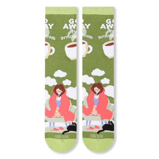 Flat lay of two olive green socks showing a person in a pink blanket, black cat, clouds, and bold white text.