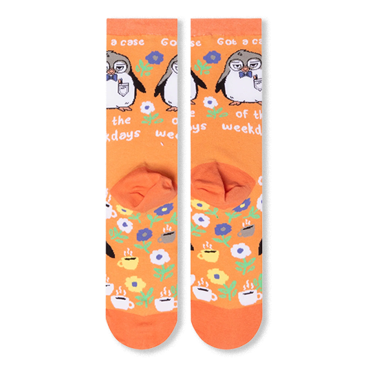 Back flat lay of orange socks revealing the heel pocket and a continued pattern of steaming coffee mugs and colorful flowers.