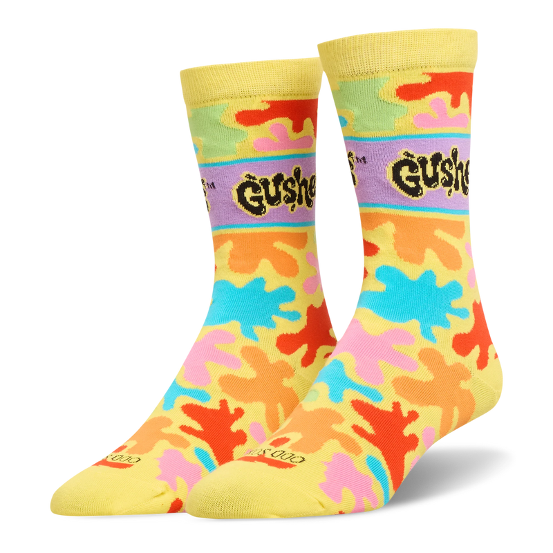 Yellow crew socks featuring bright orange, pink, blue, and green splatters, plus a purple band with the black Gushers logo.