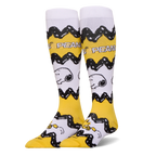 Tall yellow and white Peanuts socks featuring Charlie Brown's black zigzag pattern, Snoopy's face, and Woodstock at the toe.