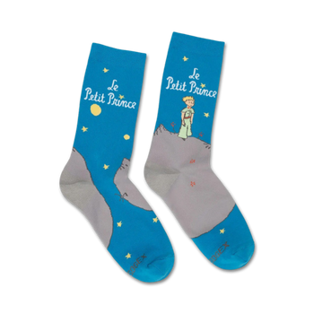 blue crew socks feature the little prince standing on a mountain range under a starry night sky.   