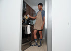 Standing at a stainless oven, an apron-clad home chef pours dry pasta from a paper box into a pot, his Hasta La Pasta socks in Navy planted on the kitchen tile. [lf]