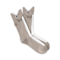 Pair of taupe crew socks with a whimsical white and black shark face design on the leg. 
