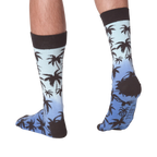 Back view of Palm Socks on a person's legs against a black background.