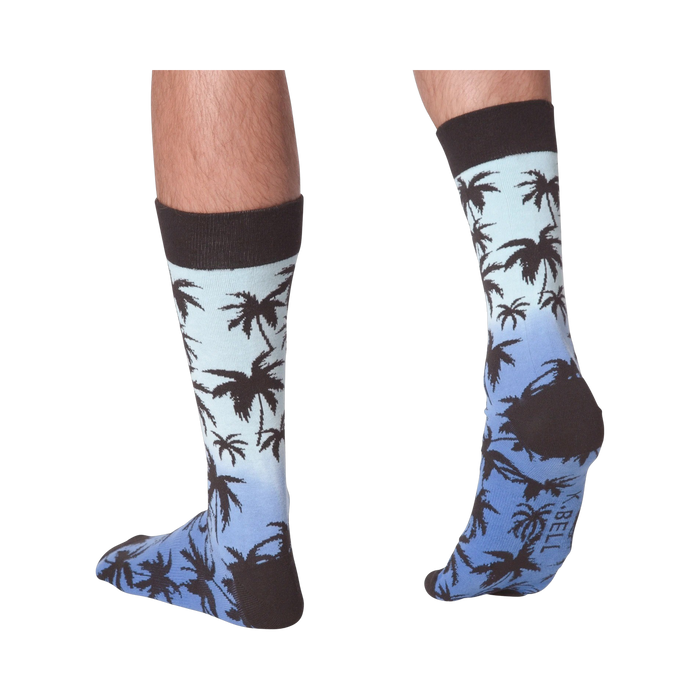 Back view of Palm Socks on a person's legs against a black background.