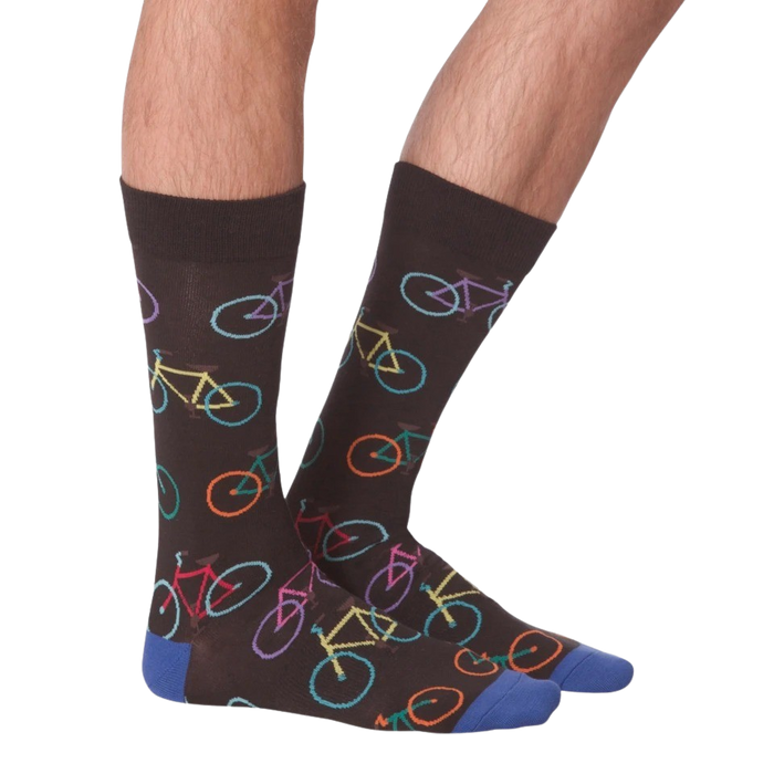 A pair of brown socks with a pattern of colorful bicycles on them. The socks have blue toes and heels.