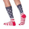 Man's legs wearing American Flag XL socks, showcasing the back and side view against a black background.
