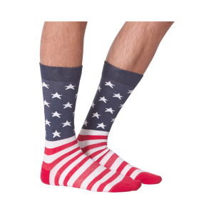 Close-up view of a pair of American Flag XL socks on a person's feet; showcasing a front view against a black background.