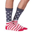 Close-up view of a pair of American Flag XL socks on a person's feet; showcasing a front view against a black background.