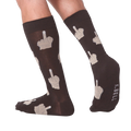 Lifestyle shot: Person's legs wearing dark brown crew socks with beige middle finger design.  K.BELL logo is visible.