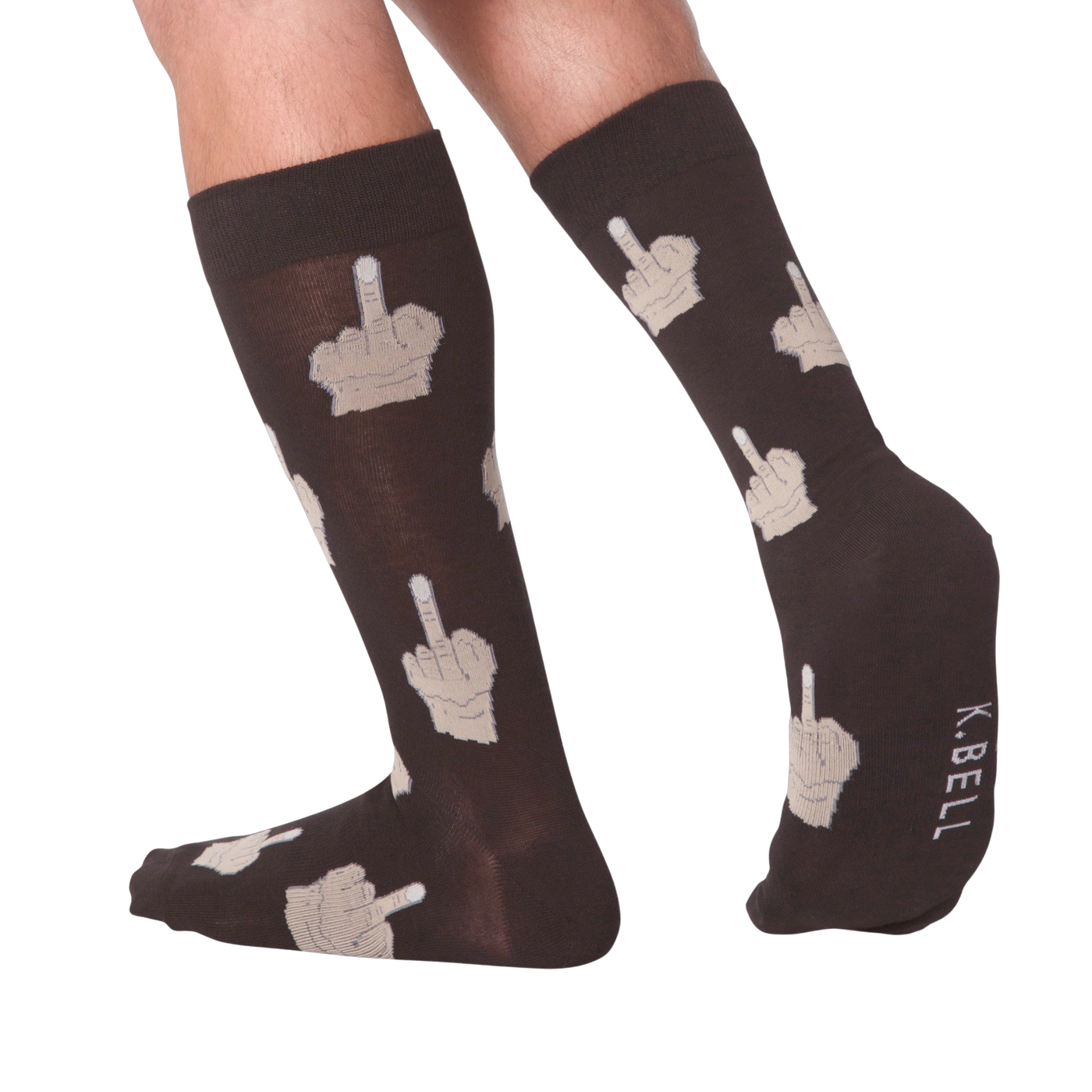 Lifestyle shot: Person's legs wearing dark brown crew socks with beige middle finger design.  K.BELL logo is visible.