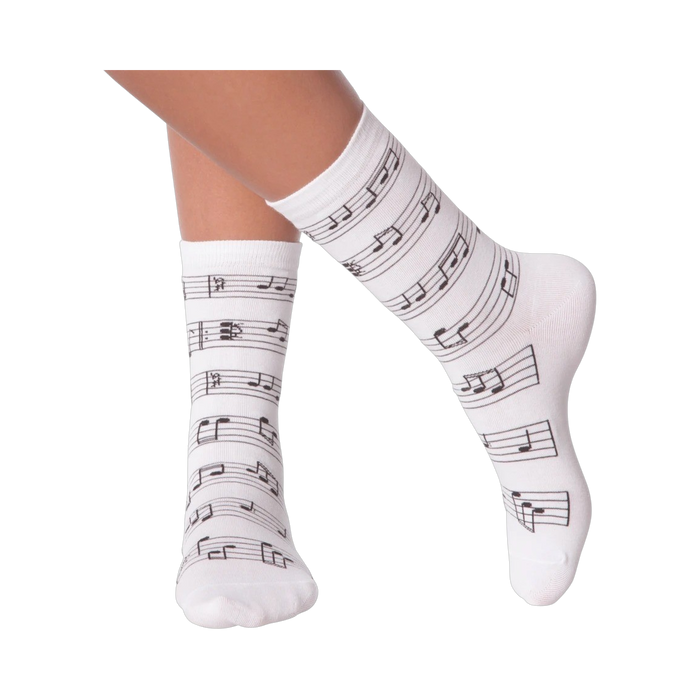 Close up of a person's legs wearing white musical note socks.