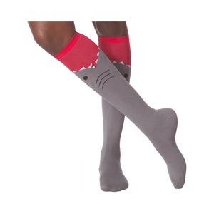 Lifestyle shot showing a person wearing the gray and red shark knee-high socks.