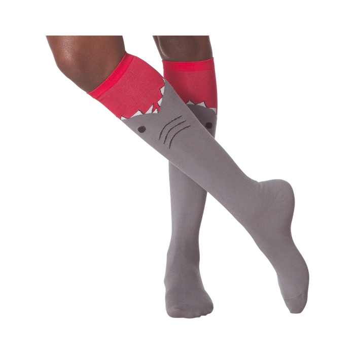 Lifestyle shot showing a person wearing the gray and red shark knee-high socks.