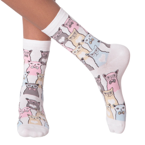 Close-up of a person's legs wearing white Smarty Cats socks.
