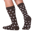 Lifestyle shot showing the socks on a person's feet.  The socks are dark brown with a tooth pattern. The image is on a black background.