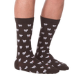 Another lifestyle shot showing the socks on a person's feet, this time from the front.  The socks are dark brown with a tooth pattern. The image is on a black background.