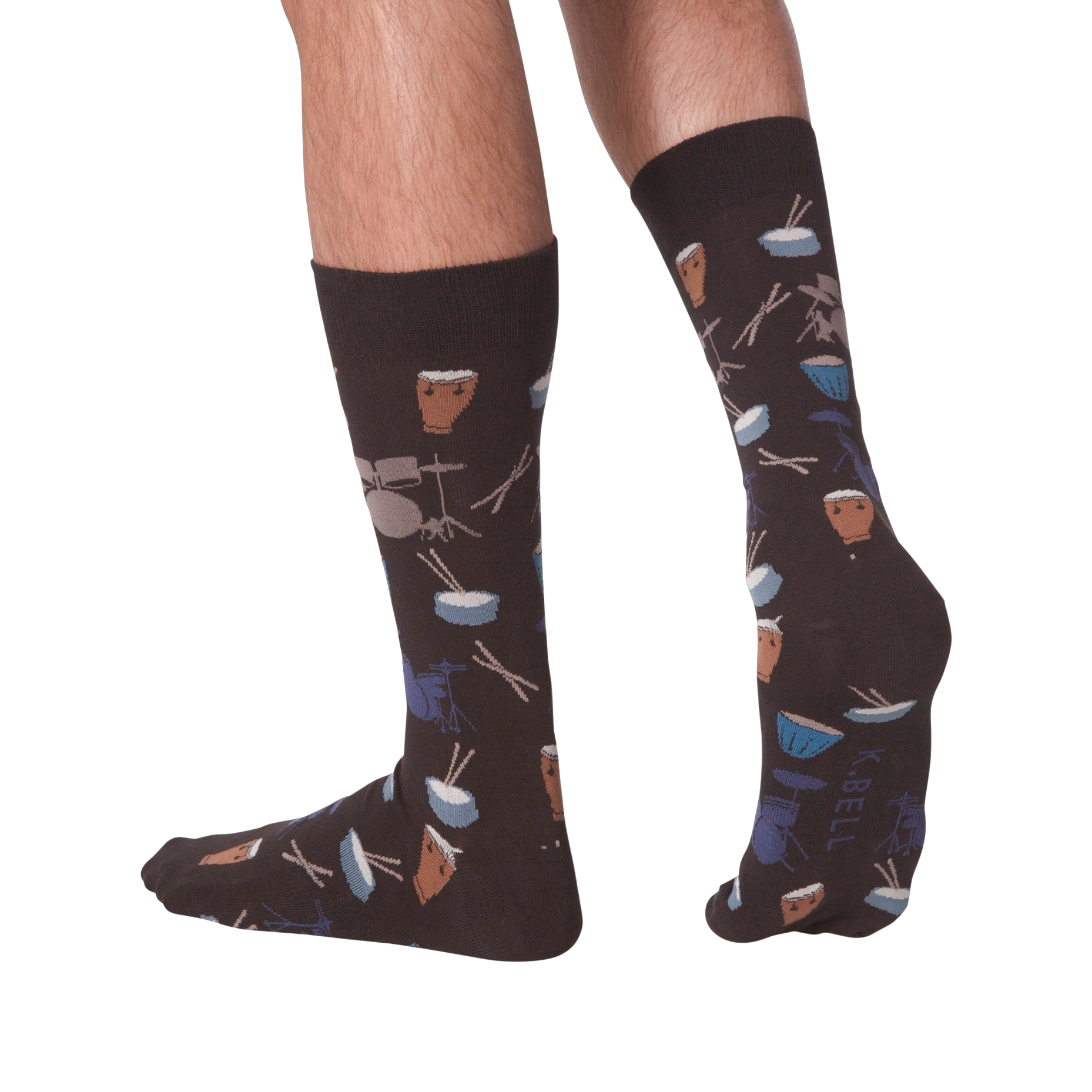 Lifestyle shot showing the 'Drums' socks on a person's legs from the back. The socks are dark brown with a drum set pattern.