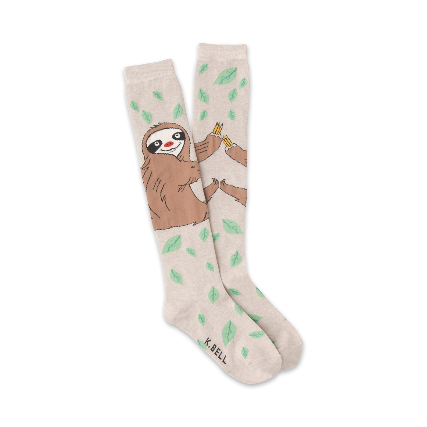 A pair of beige knee-high socks with a playful illustration of sloths sharing bananas amidst scattered green leaves.