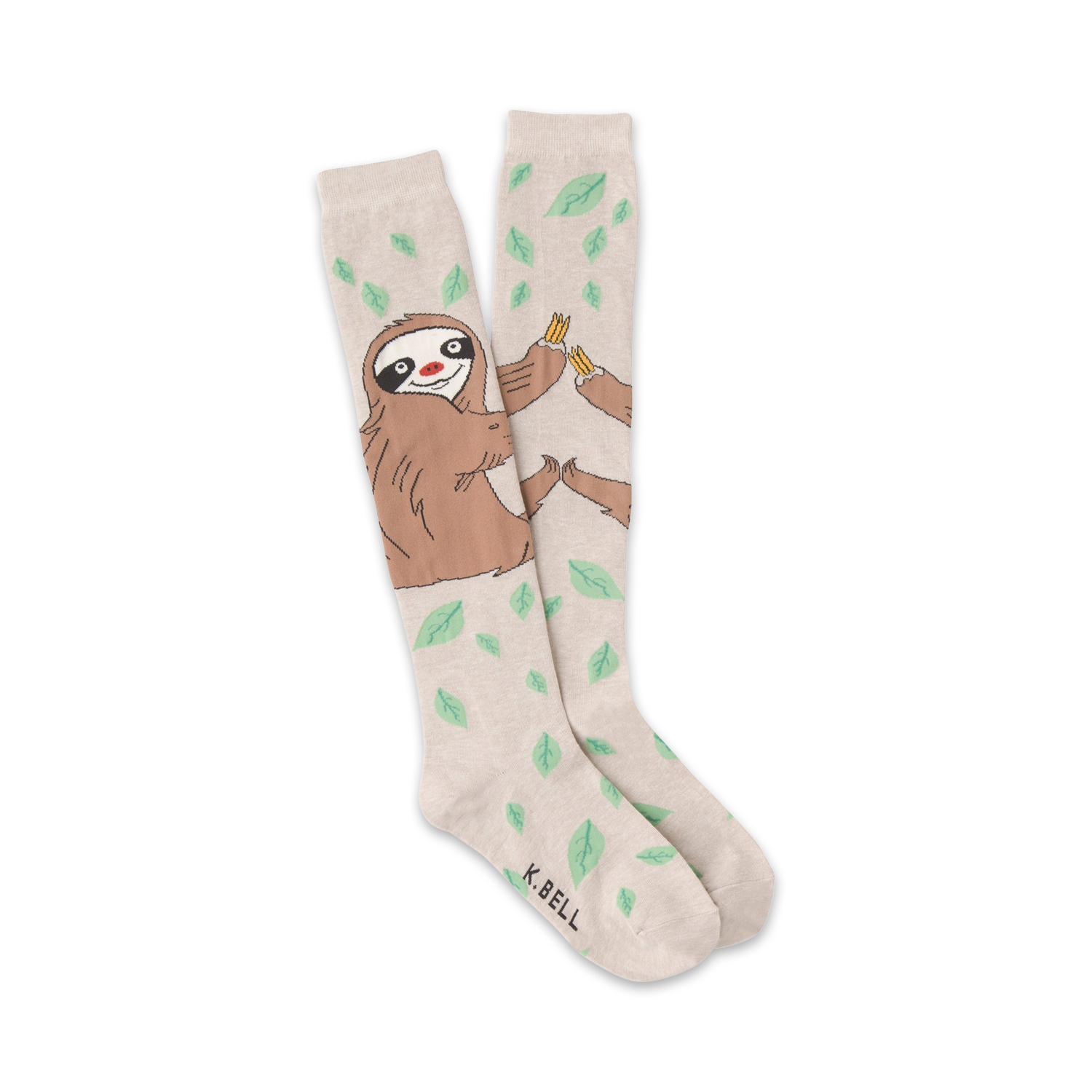 A pair of beige knee-high socks with a playful illustration of sloths sharing bananas amidst scattered green leaves.