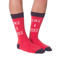 Lifestyle shot: A person's legs wearing the 'Like A Boss' red crew socks with navy cuffs.
