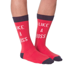 Lifestyle shot: A person's legs wearing the 'Like A Boss' red crew socks with navy cuffs.