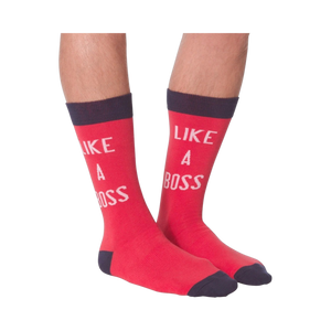 Lifestyle shot: A person's legs wearing the 'Like A Boss' red crew socks with navy cuffs.