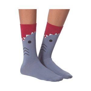 Flatlay showcasing a pair of blue crew socks with a shark face design.