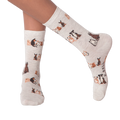 Lifestyle shot of woman's legs wearing the grey crew socks with the dog pattern.
