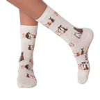 Lifestyle shot of woman's legs wearing the grey crew socks with the dog pattern.