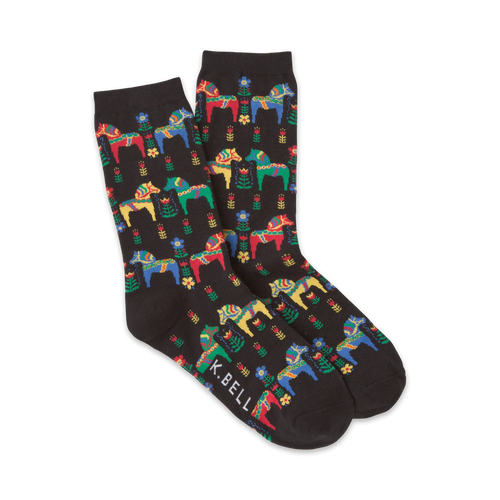 Pair of crew socks with a black background featuring a pattern of colorful Swedish Dala horses and flowers. The socks are predominantly black, red, yellow, blue, and green.