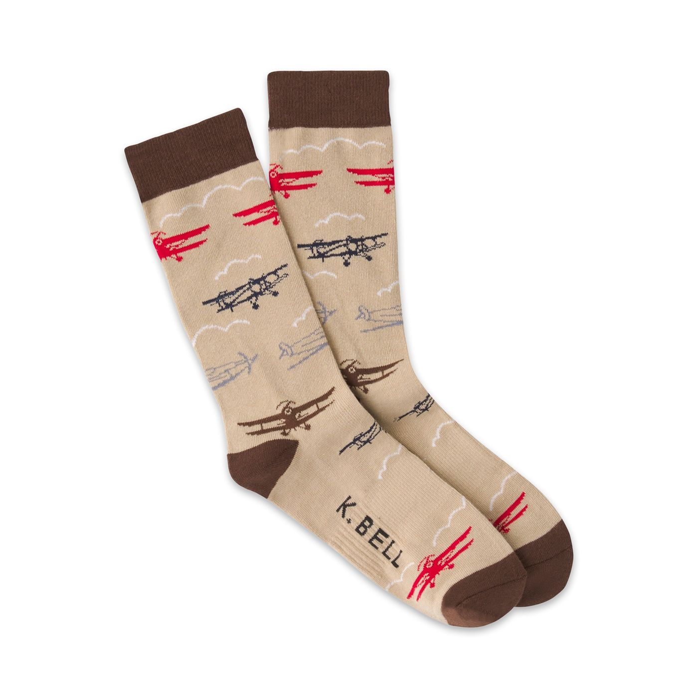 Pair of beige crew socks with a pattern of red, brown, and navy biplanes and clouds. Brown cuff. 'K.Bell' subtly printed on the sock.