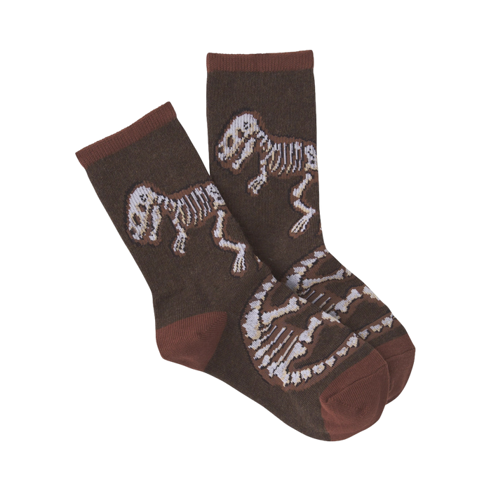Pair of brown crew socks with a pattern of beige dinosaur skeletons. 