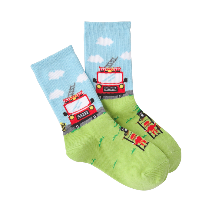 Pair of crew socks; light blue with clouds and red firetruck, lime green with firefighter and tree. Playful design.