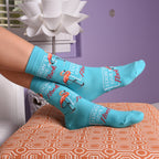 Lifestyle shot of model's legs with 'I Don't Give a Flock' socks on a couch.