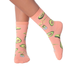 Lifestyle shot of woman's legs wearing peach avocado socks.